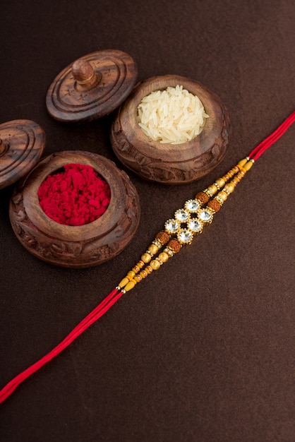 Raksha Bandhan mit einem eleganten Rakhi, Reiskörnern und Kumkum. Ein traditionelles indisches Armband, das ein Symbol der Liebe zwischen Brüdern und Schwestern ist.