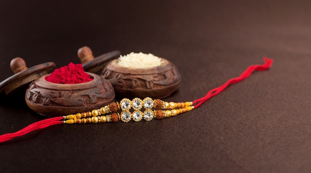 Raksha Bandhan mit einem eleganten Rakhi, Reiskörnern und Kumkum