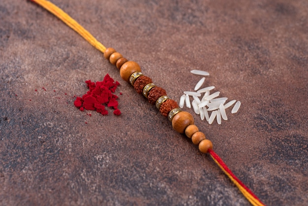 Raksha Bandhan: Rakhi con granos de arroz y kumkum sobre fondo de piedra