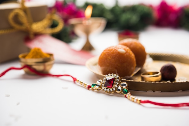 Raksha Bandhan / Rakshabandhan Rakhi mit Haldi Kumkum Reis, süßer Mithai, Geschenkbox, selektiver Fokus