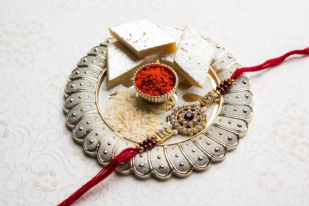 raksha bandhan saudação rakhi e presente com doce kaju katli ou mithai e grãos de arroz kumkum