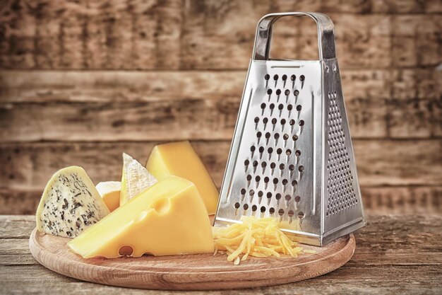 Foto ralador e queijo em fundo de madeira