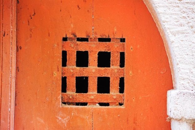 Ralar em uma velha porta laranja Filmado em Bosa Itália