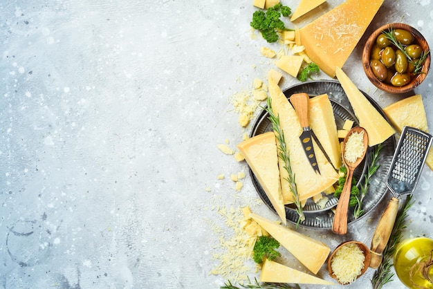 Rallador de queso y queso parmesano duro contra un fondo de piedra gris Fondo de alimentos Espacio libre para texto