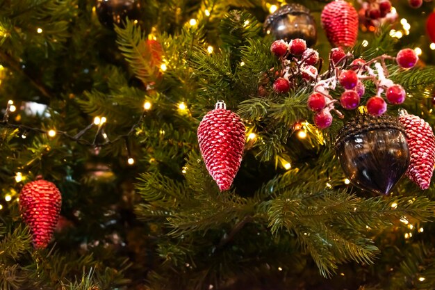 Rama de abeto con bolas y luces festivas en el fondo navideño con destellos.