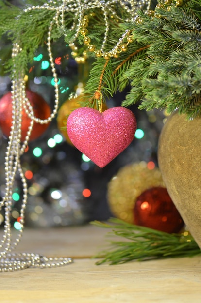 Rama de abeto con una decoración de corazón rosa Corazón rosa colgando de la rama del árbol de Navidad