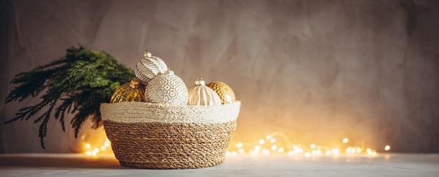 Rama de árbol de Navidad y adornos en canasta tejida con luces de bokeh de Navidad en el fondo