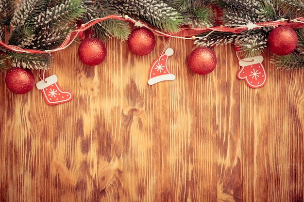 Rama de árbol de Navidad con adornos sobre fondo de madera. Concepto de vacaciones de Navidad
