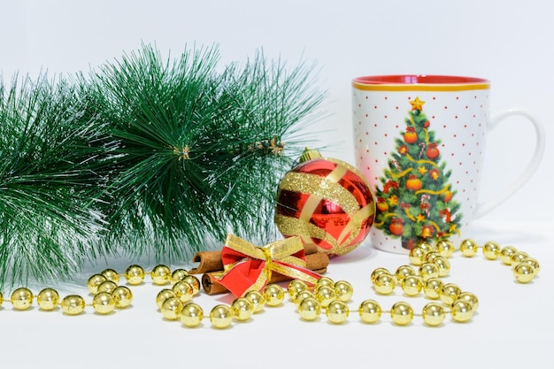 rama de árbol de navidad con adornos y taza de navidad