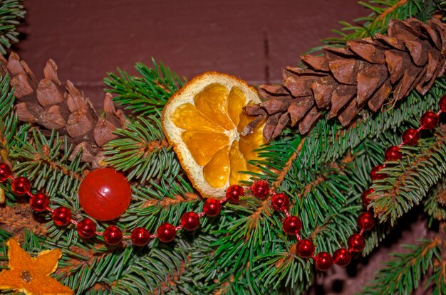 Rama de árbol de navidad con conos de abeto garland cookies y mandarinas de cerca