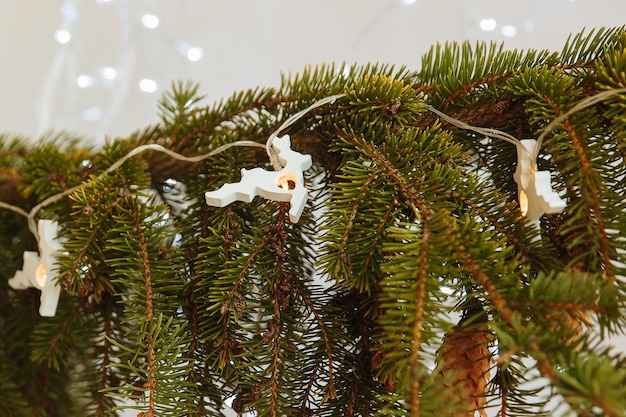 una rama de un árbol de Navidad con una guirnalda en forma de ciervo