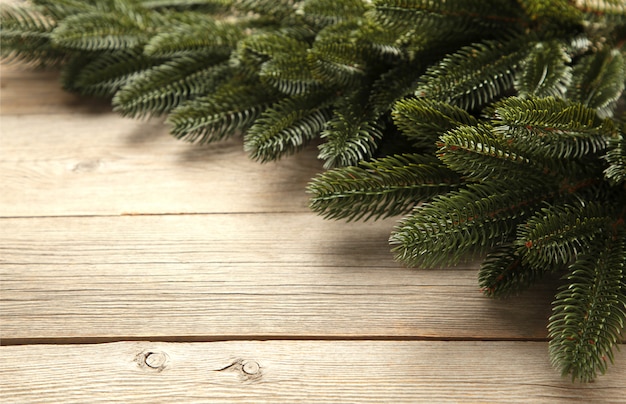 Rama de un árbol de navidad en la mesa de madera gris.