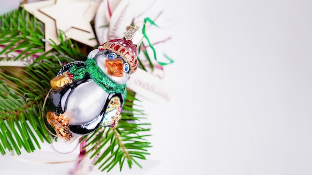 Rama de árbol de Navidad y pingüino vintage divertido sobre un fondo blanco.