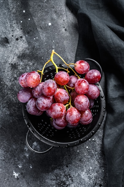 Una rama de uvas rojas jugosas en un colador