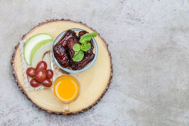 Ramadan Inspiration zeigt Dattelpalmen in einer Schüssel mit Früchten und Orangensaft