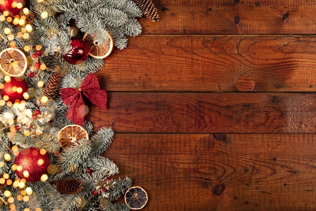 Ramas de abeto adornos navideños y luces doradas sobre un fondo de madera vieja Navidad