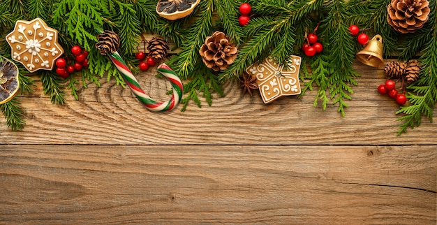 Ramas de abeto y adornos navideños sobre fondo de madera.