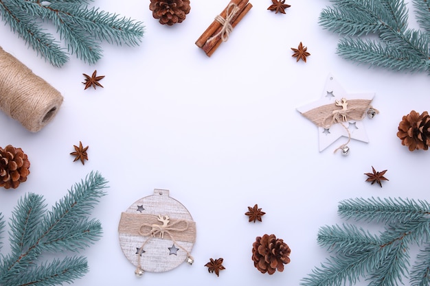 Ramas de abeto con juguetes de navidad sobre un fondo blanco.