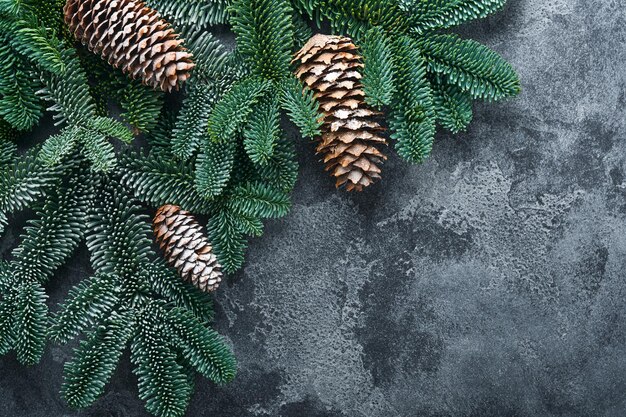 Ramas de abeto de Navidad, bolas de Navidad, caja de regalo, copos de nieve de madera y estrellas en la mesa de piedra gris para sus saludos navideños. Vista superior con espacio de copia. Tarjeta de felicitación de Navidad.