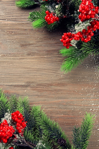 Ramas de abeto de Navidad con serbal en mesa de madera