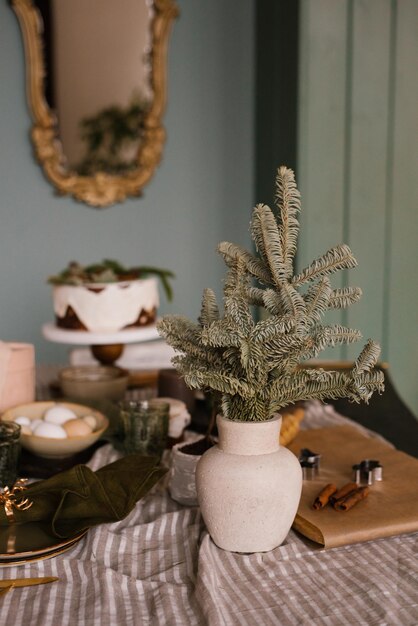 Foto ramas de abeto o abeto en un jarrón de cerámica en una mesa festiva decorada para navidad