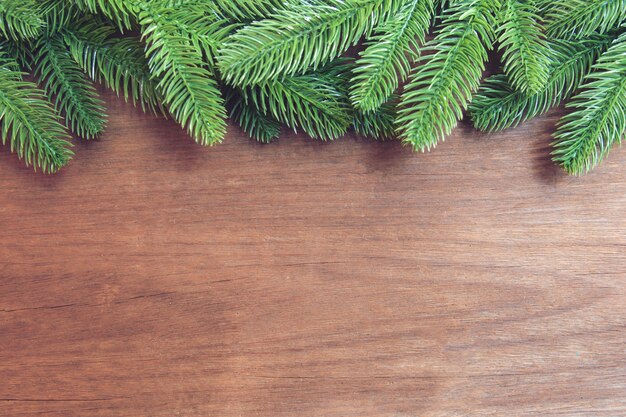 Ramas de abeto y piñas con decoración sobre tabla de madera.