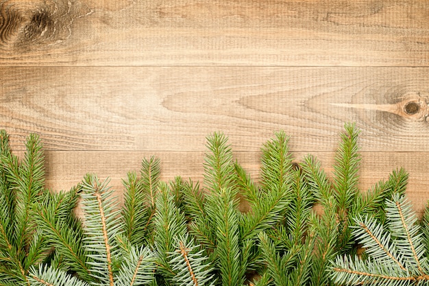 Ramas de abeto sobre fondo de madera con espacio de copia