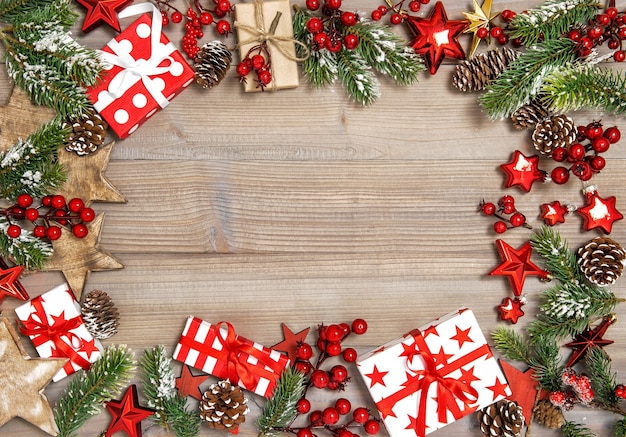 Ramas de árbol de marco de Navidad, cajas de regalo y adornos rojos
