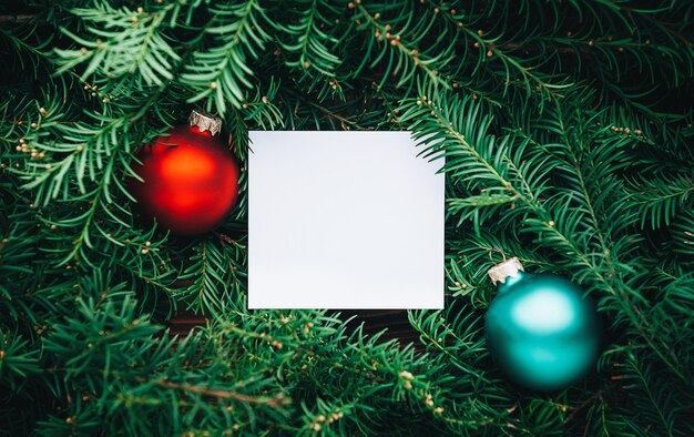 Ramas de un árbol de Navidad y una hoja de papel vacía.