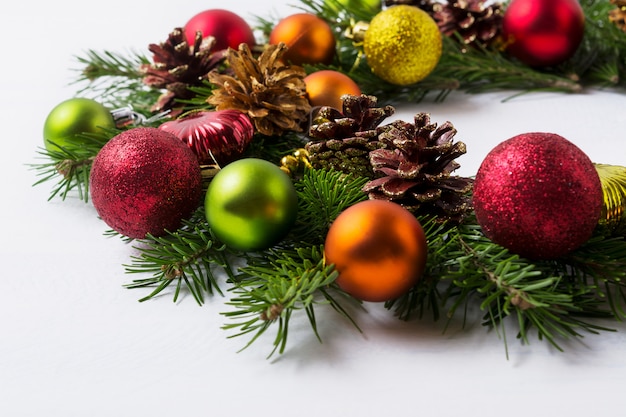 Ramas de los árboles de Navidad con adornos rojos, verdes, naranjas y amarillos.