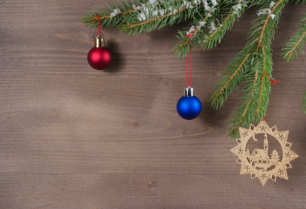 Ramas de los árboles de Navidad con adornos sobre un fondo de madera