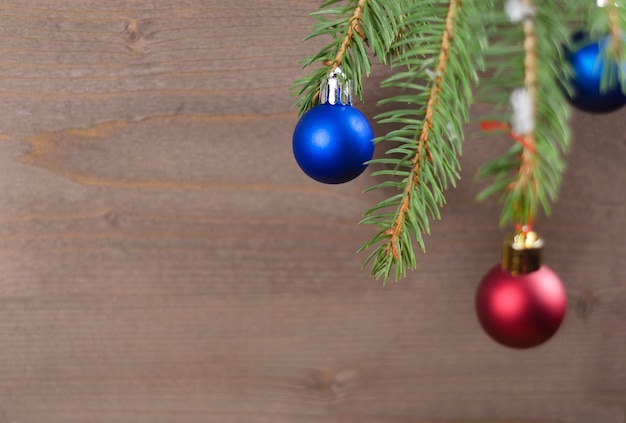 Ramas de los árboles de Navidad con adornos sobre un fondo de madera