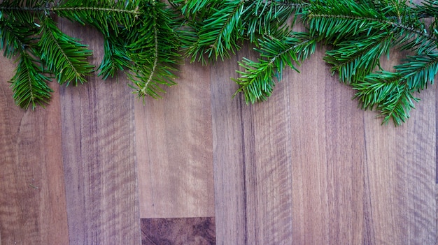 Ramas de los árboles de Navidad en el fondo de madera