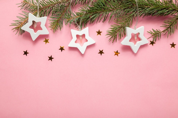 Ramas de los árboles de Navidad con una guirnalda sobre un fondo rosa, celebraciones de Navidad y Año Nuevo