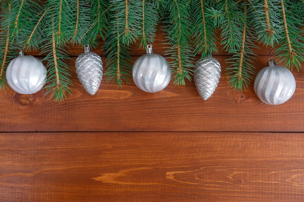 Ramas de los árboles de Navidad con juguetes de año nuevo sobre fondo de madera