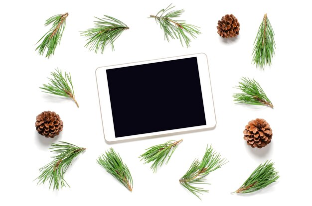 Foto ramas de los árboles de navidad con piñas y tableta