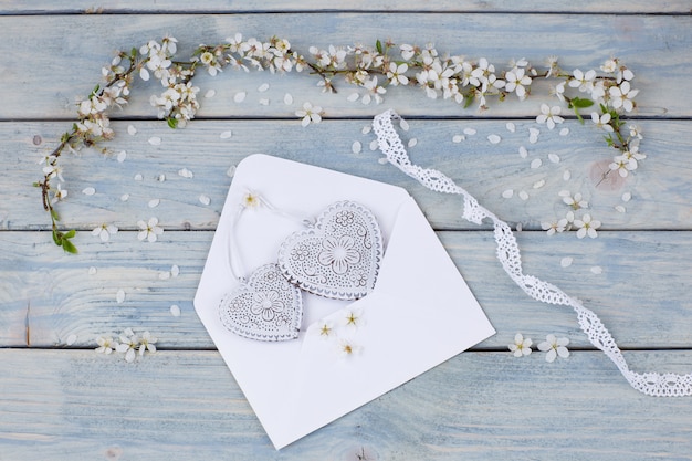 Foto ramas de cerezo blanco en flor y un sobre con corazones blancos