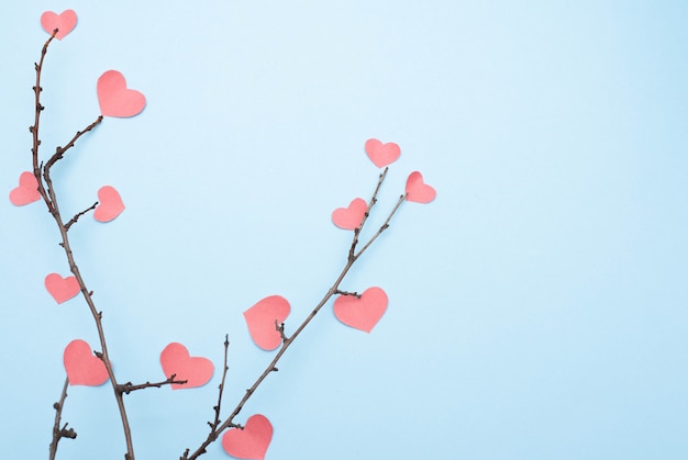 Ramas con corazones sobre fondo azul con espacio de copia