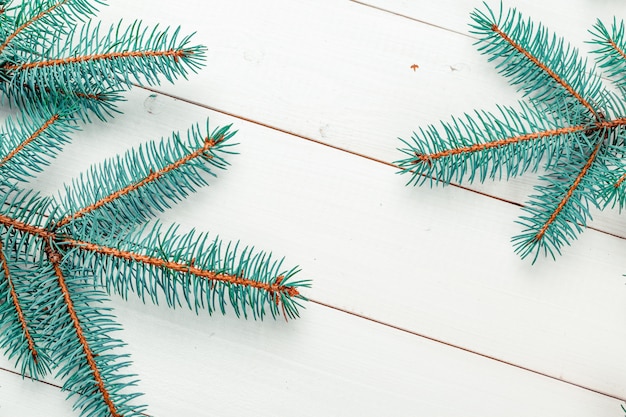 Ramas de pino de Navidad sobre tabla de madera.