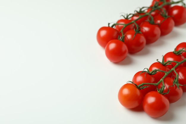 Ramas de tomate cherry fresco sobre fondo blanco.