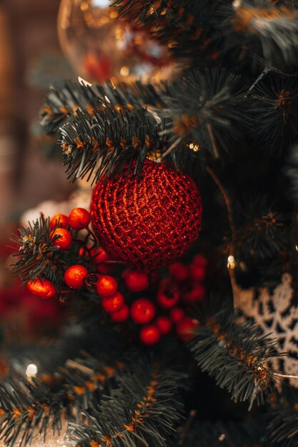 Ramas verdes del árbol de Navidad decoradas con bayas rojas y bola de Navidad Año nuevo temporada de invierno