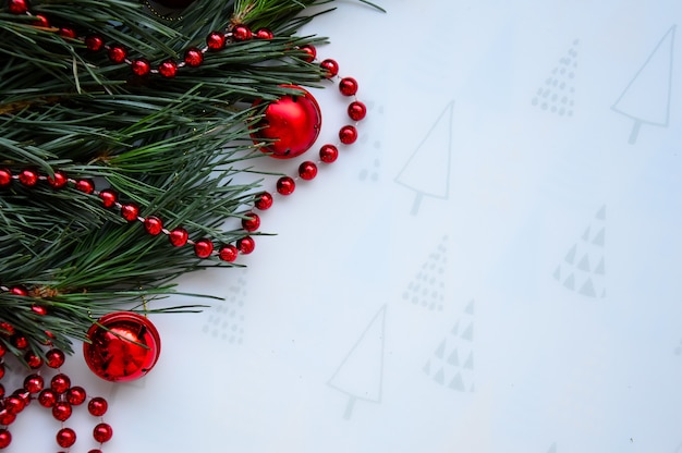 Foto las ramas verdes del pino están decoradas con bolas rojas, fondo navideño y tarjeta de año nuevo.