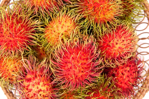 Rambután en canasta sobre fondo blanco