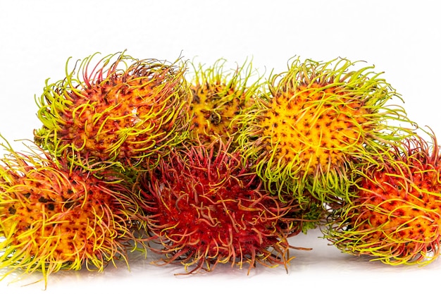 El rambután fresco aislado con hoja verde. Rambután fresco en cesta de bambú en blanco