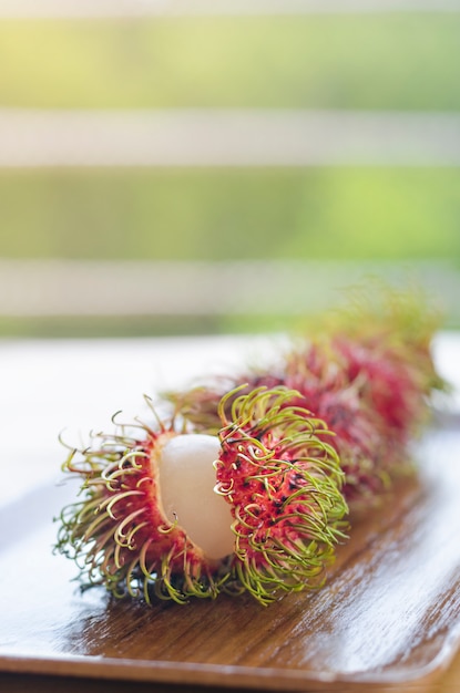 Rambután fresco en mesa de madera