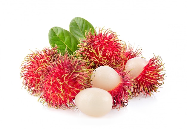 Rambután con hojas en mesa blanca.