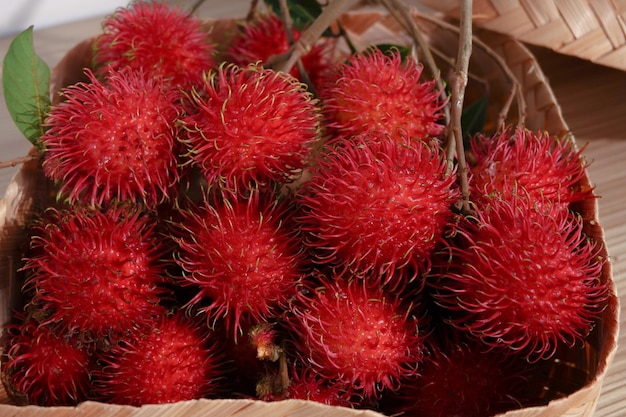 Rambutan mit tropischen Früchten in einem geflochtenen Bambuskorb