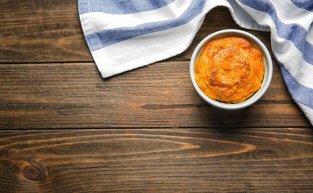 Ramekin con sabroso soufflé de zanahoria sobre mesa de madera