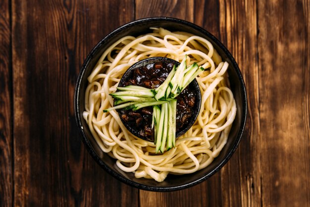 Ramen macarrão de ovo decorado pepino em tigela preta