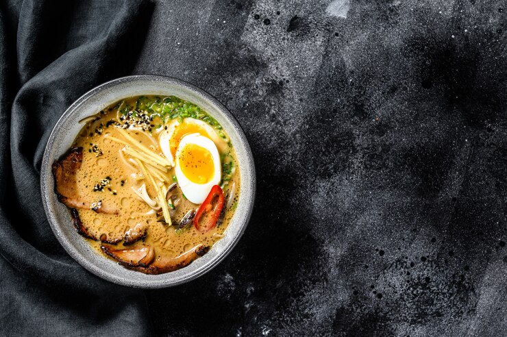Foto ramen sopa de macarrão asiático com carne de língua de carne, cogumelos e ovo em conserva de ajitama. fundo preto. vista do topo. copie o espaço